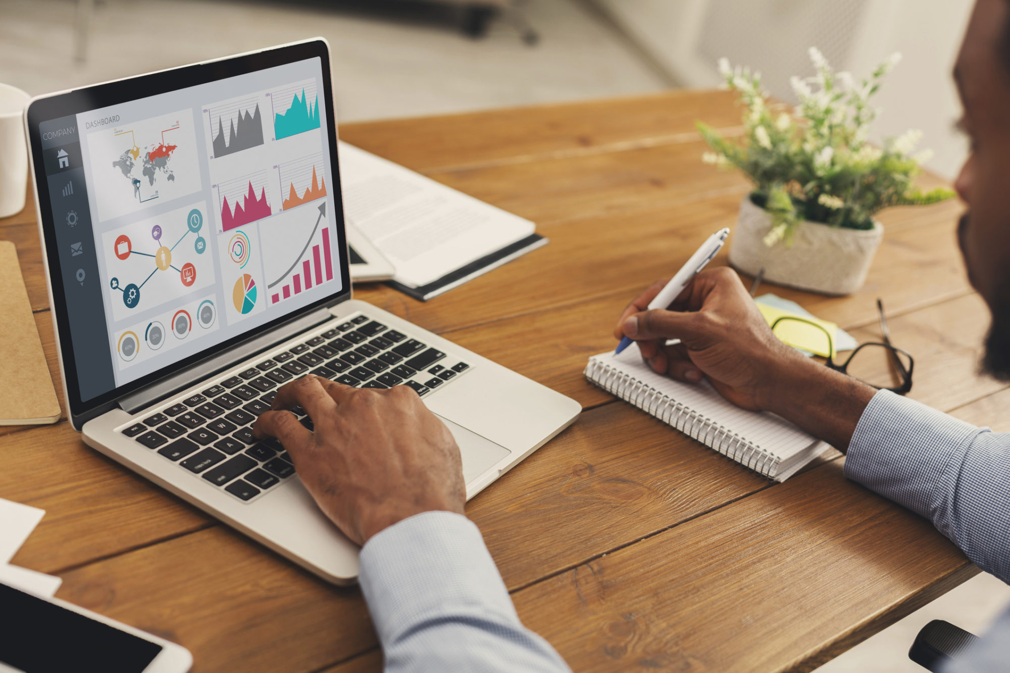 Black entrepreneur analyzing graph on laptop at workplace